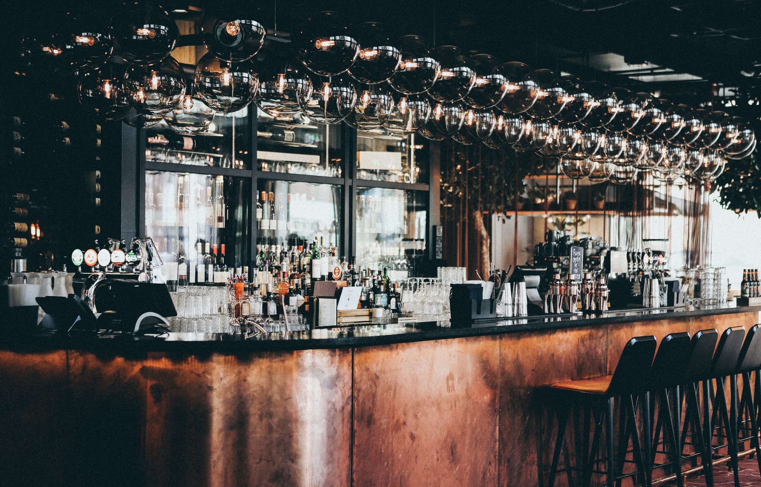 Wide shot of bottles and glasses in display cabinet at a bar in Scandic Hotel in Copenhagen, Denmark