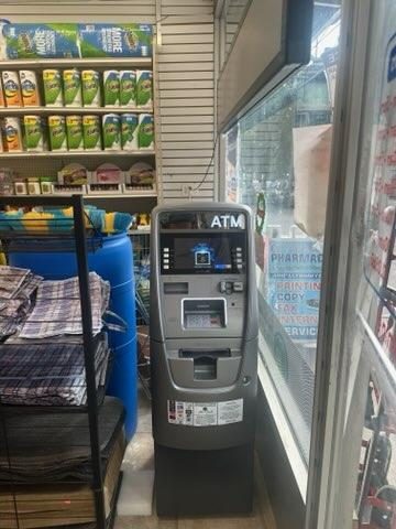 ATM standing by the front window in a convenience store